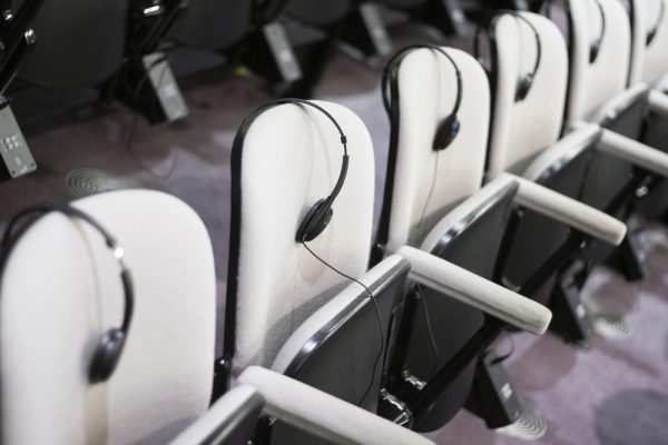 Stühle mit Kopfhörern als Teil der benötigten Konferenztechnik